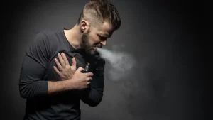 a man coughing from a ghost inhale vape trick that he was performing